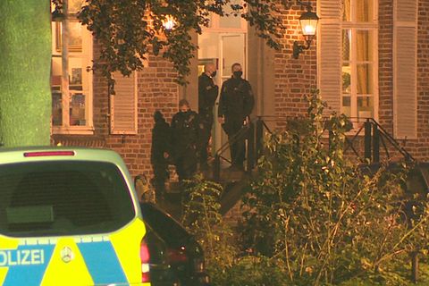 Polizeibeamte gehen in ein Haus auf dem Areal einer Eventagentur in Goch am Niederrhein