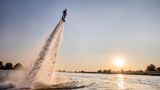 Ein Flyboard-Flieger auf der Elbe. Ich war mit einem DLRG-Boot auf dem Fluss unterwegs. Bei einem Großcampingplatz bei Geesthacht vergnügten sich die gelangweilten Kids der Dauercamper mit einem neuartigen Freizeitvergnügen. Die ersten Fotos davon wurden mir dann jedoch samt nagelneuer Kamera beim Ausladen vor der Haustür in Hamburg in einem drive by-Raub vom Beifahrer eines vorbeifahrenden Autos gestohlen. Da wurde ich schon beraubt in Neapel, Nairobi und Bogotá – und nun auch in der feinen Hansestadt.