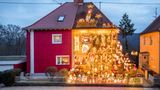 Ein Haus bei Völklingen im Saarland. Eigentlich hatte ich schon weihnachtliche Doppelhaushälften in Delmenhorst fotografiert. Und dort von einer zerstrittenen Nachbarschaft erfahren, weil die Touristen gelegentlich auf den gepflegten Zierrasenflächen der Wohnstraße wendeten und ihre Kinder in die Hecken pinkelten. Im Saarland war die Situation offenbar noch aufgeheizter. Ein netter Türke, in dessen Vorgarten ich mein Stativ aufstellte, wollte Frieden zwischen den Deutschen stiften und mir das Fotografieren verbieten. Denn nach einer Veröffentlichung in der "Bild"-Zeitung hatte der abendliche "Übertourismus" noch zugenommen, war der Streit unter den Nachbarn eskaliert. Ich sagte, dass ich bloß "Kunst" machen wolle. Also keinen Ärger. "Kunst" nahm der Herr nicht so ernst; ich durfte die wenigen Minuten nutzen, bevor wieder Schaulustige die Straße bevölkerten.