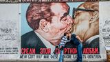 Die East Side Gallery in Berlin, mit dem bekannten Gemälde von Dmitry Vrubel: "Honecker küsst Breschnew". Ganze Busladungen von Touristen werden vor der innigen sozialistischen Freundschaft ausgeladen, und im Minutentakt nutzen auch Liebespaare die Szene für ihr privates Berlin-Bild. Ich fotografierte Vrubel in den 1990er Jahren mehrmals in Moskau. Mittlerweile malte er auch Putin und lebt jetzt in Berlin.