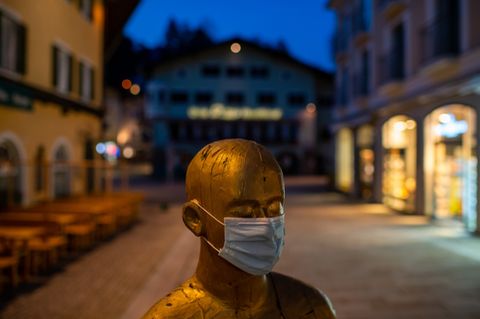 Eine Statue mit Mundschutz in der leeren Fußgängerzone von Berchtesgaden.