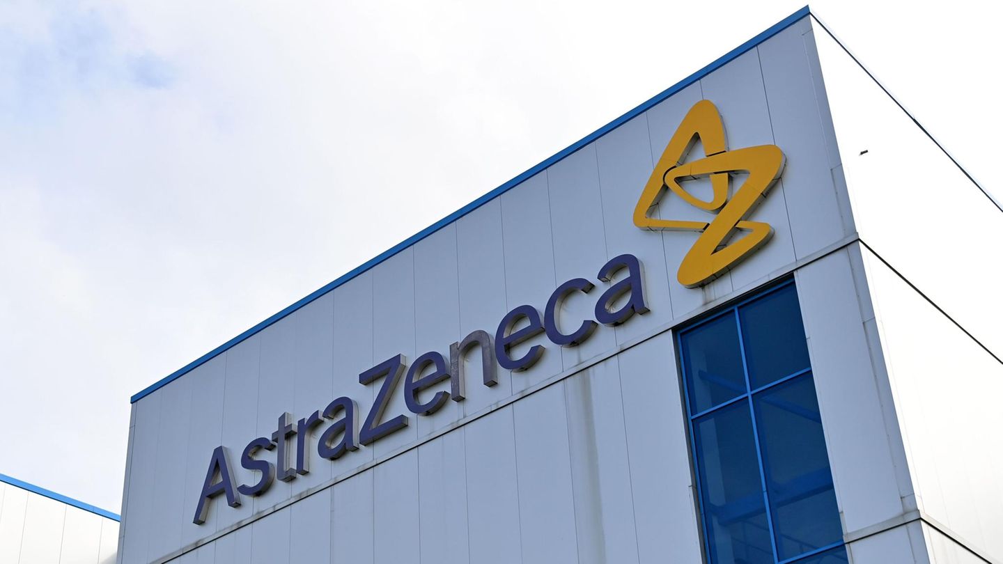 An einer weißen Wellblech-Fabrikhalle hängt der Schriftzug "AstraZeneca", daneben ein gelbes Logo aus stilisierten Buchstaben