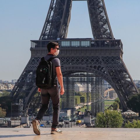 Ein Passant geht mit Mundschutzmaske über den Place du Trocadéro