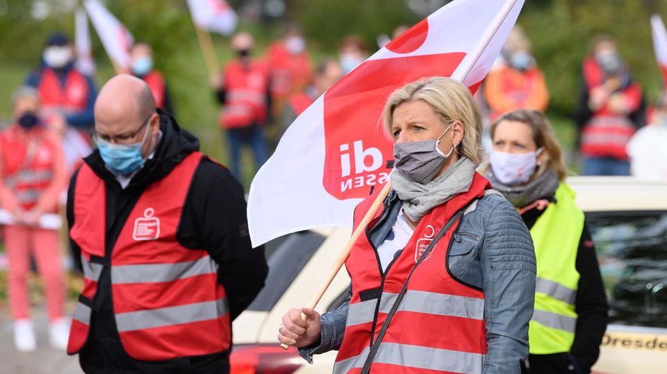 Sachsen, Dresden: Teilnehmer eines ganztägigen Warnstreiks stehen während einer Kundgebung auf dem Güntzplatz