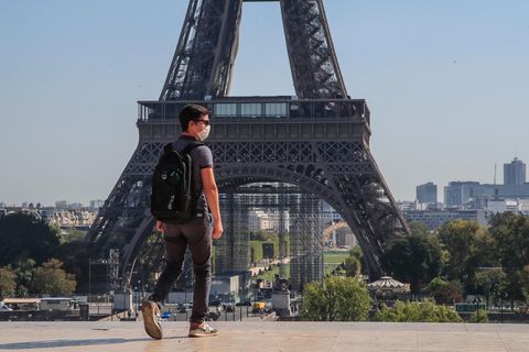 Frankreich, Paris: Ein Passant geht mit Mundschutzmaske über den Place du Trocadéro