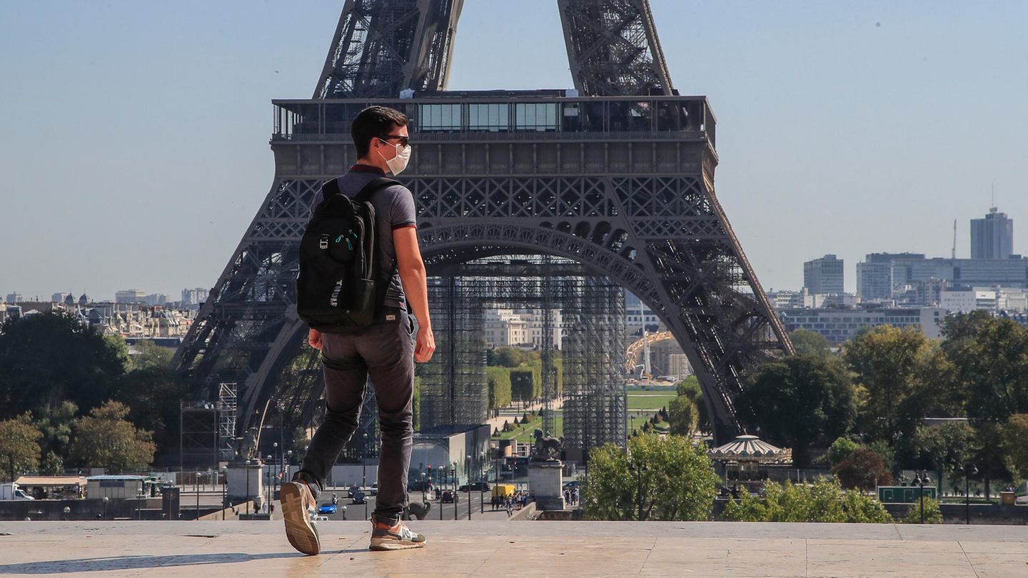 Frankreich, Paris: Ein Passant geht mit Mundschutzmaske über den Place du Trocadéro