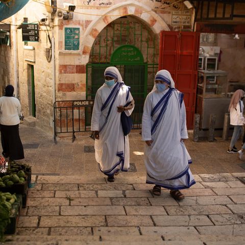 Israel, Jerusalem: Katholische Nonnen gehen mit Mund-Nasen-Schutz über einen Platz in der Altstadt von Jerusalem