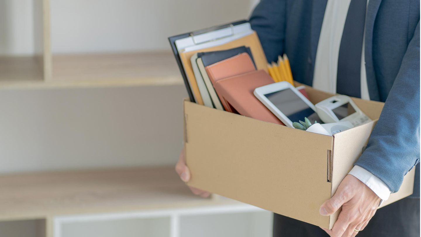 Mann verlässt mit Kiste das Büro