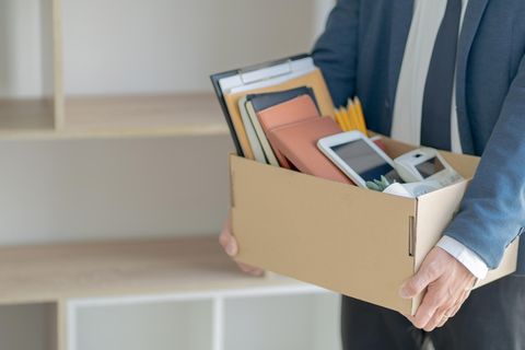 Mann verlässt mit Kiste das Büro