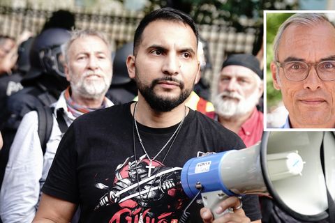 Attila Hildmann steht in einer Menschenmenge und hält ein Megafon in der linken Hand