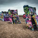 USA: Amarillo  Diese aus dem Boden ragenden alten Straßenkreuzer sind ein berühmtes Kunstwerk, das 1974 neben der Route 66 in Texas errichtet wurde. Im Laufe der Zeit sind die Karosserien immer wieder übersprüht worden.
