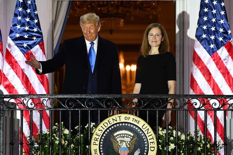 Donald Trump und Amy Coney Barrett vor US-Flaggen auf dem Balken des Weißen Hauses