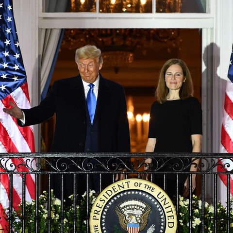 Donald Trump und Amy Coney Barrett vor US-Flaggen auf dem Balken des Weißen Hauses