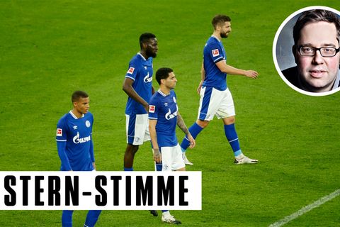 Vier Fußballspieler in blauen Schalke-Trikots gehen niedergeschlagen über den Platz