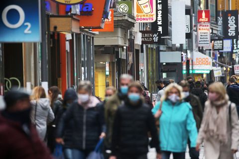 Nordrhein-Westfalen, Köln: Menschen gehen mit Schutzmasken durch die Fußgängerzone