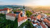 Tschechien, Český Krumlov: Burg und Schloss  Das gesamte Gebäudeensemble wird vom Schlossturm überragt, der das bedeutendste Wahrzeichen Český Krumlovs ist. Im Hintergrund ist die böhmische Landschaft mit der Moldau zu sehen.