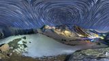 Georgien, Kaukasus: Panorama bei Nacht   Wo kann man perfektere Sternenstreifen fotografieren als in einer Naturlandschaft, deren Himmel von keinerlei künstlichen Lichtern verschmutzt ist? Eine Dauerbelichtung zeichnet die Bahnen der Sterne im Verlauf der Nacht auf. Das Resultat ist diese Aufnahme,  die die kaukasische Berglandschaft in einer magischen Beleuchtung zeigt-