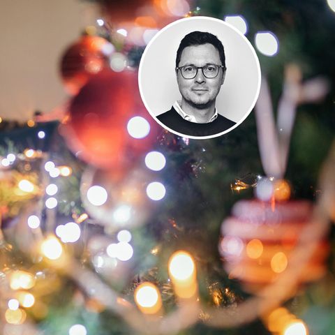 Ein Mädchen mit Maske schmückt den Weihnachtsbaum