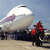 Bild 1 von 12 der Fotostrecke zum Klicken:  Begrüßung im Jahre 1979 auf Thailändisch, indem die erste Boeing 747 in der Flotte von Thai Airways von zwei Elefanten über das Rollfeld gezogen wird..