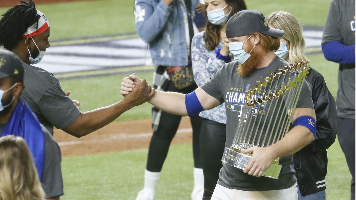 Justin Turner (rechts) von den Los Angeles Dodgers feiert nach dem Spiel mit der World-Series-Trophäe
