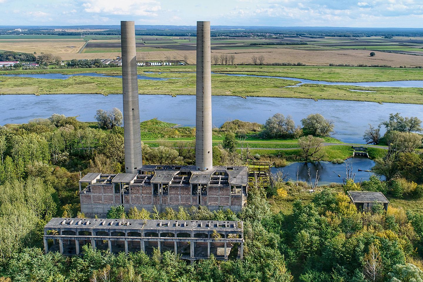 Bauruine des Großkraftwerks Vogelsang  Zwei 100 Meter hohe Schornsteine ragen am Ufer der Oder empor, schon seit den 1940er Jahren. Mit Zwangsarbeitern aus dem KZ Sachsenhausen wurde dieses Braunkohlekraftwerk nordöstlich vom heutigen Eisenhüttenstadt errichtet – doch nie fertiggestellt.