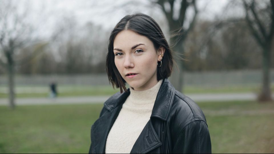 Eine Frau steht vor Bäumen Eine Frau steht vor Bäumen