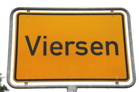 Ein gelbes Ortsschild zeigt vor weißem Himmel den Namen "Viersen"