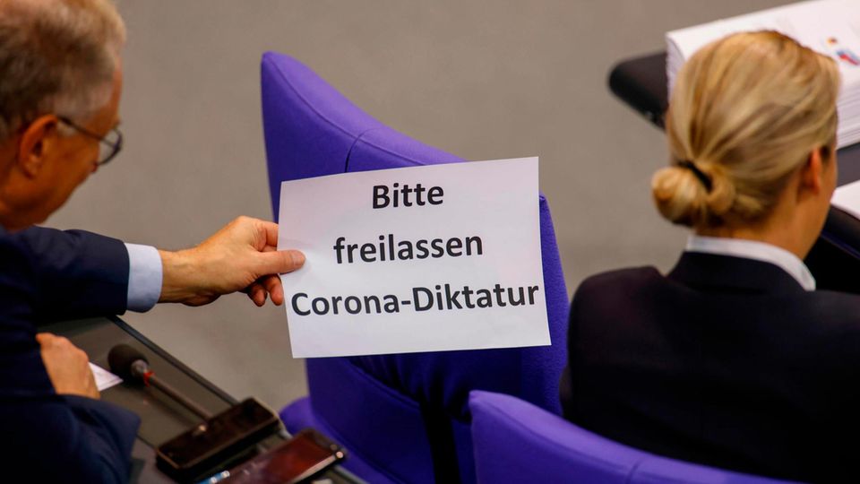 Ein AfD-Bundestagsabgeordneter zeigt Fraktionschefin Alice Weidel ein Blatt mit dem neuen Hauptthema der AfD
