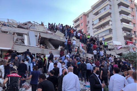 Menschen auf den Trümmern eines durch ein Erdbeben eingestürztes Haus in Izmir