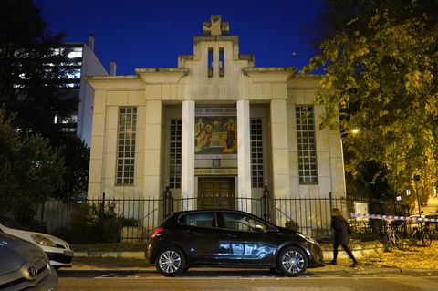 Vor einem dunkelblauen Abendhimmel steht ein Sandsteinbau mit zwei Säulen vor dem Portal