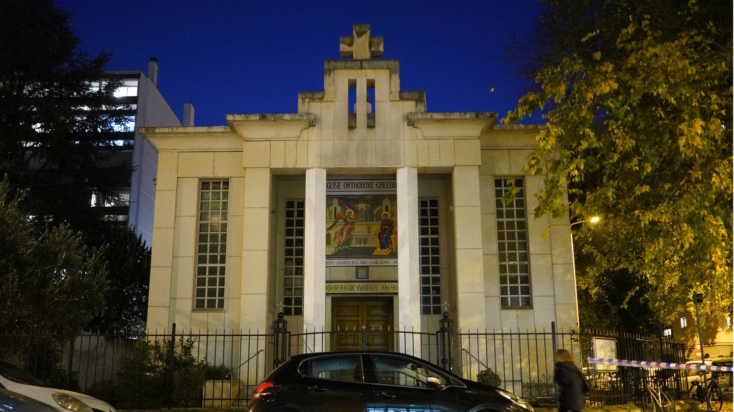 Vor einem dunkelblauen Abendhimmel steht ein Sandsteinbau mit zwei Säulen vor dem Portal