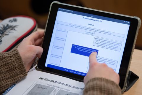 Eine Schülerin einer 9. Klasse arbeitet im Unterricht mit ihrem iPad.