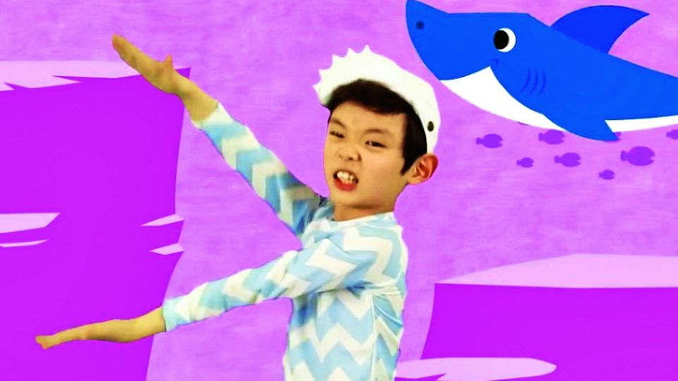 Ein Kind tanzt den Baby Shark-Tanz im Originalvideo, vor einem pinken Hintergrund