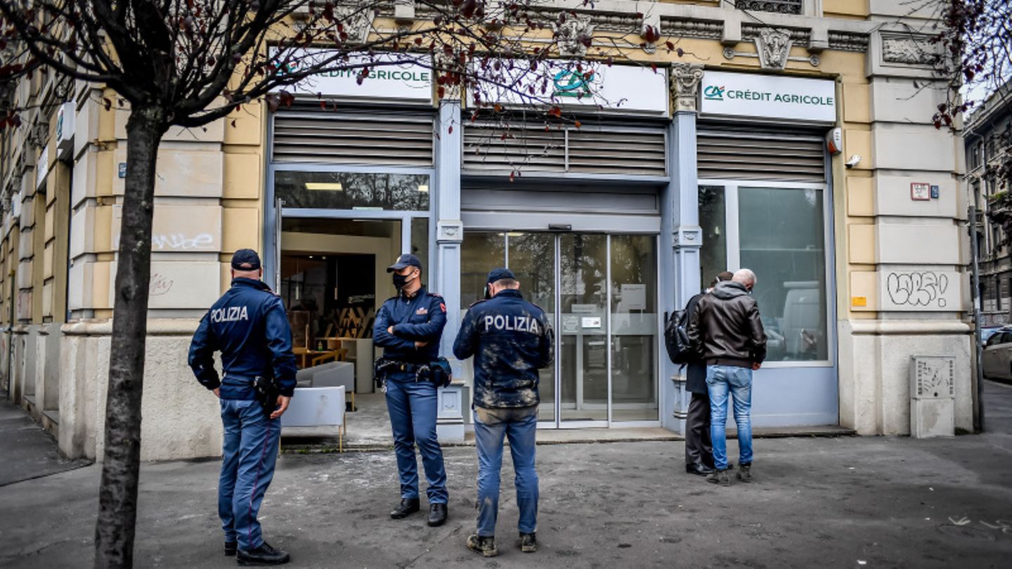 Nach einem Banküberfall in Mailand bewachen Polizisten eine Filiale der Bank Credite Agricole.