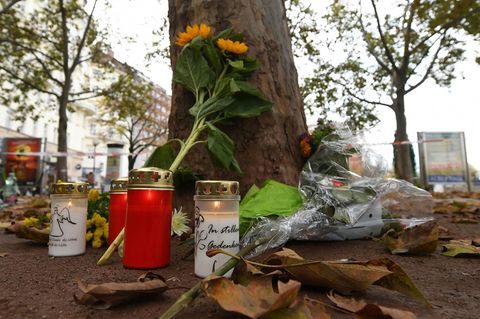 Kerzen und Blumen liegen im Bereich des Tatorts einer Terror-Attacke zum Gedenken an die Opfer