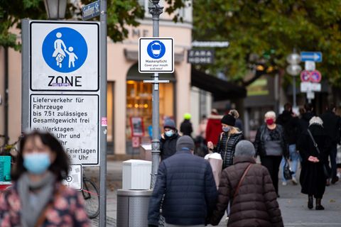 In der Innenstadt von München weist ein Schild auf die geltende Maskenpflicht zur Eindämmung des Coronavirus hin
