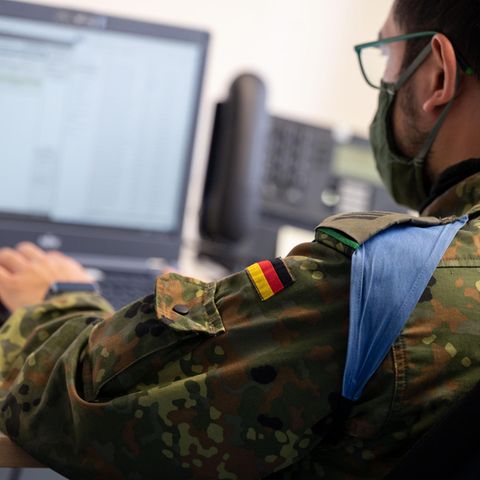 Ein Soldat sitzt vor einem Computer.