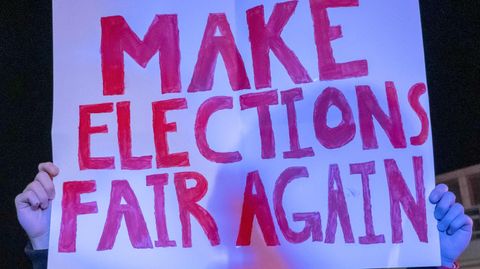 Ein Trump-Anhänger mit einem Plakat "Make Elections Fair Again"