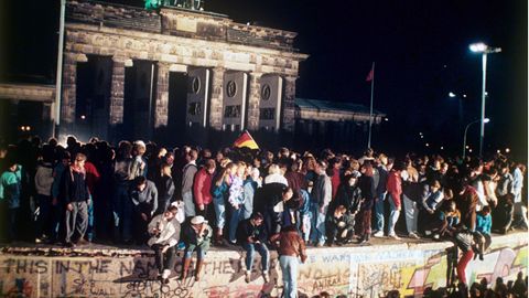 9. November 1990: Die Mauer fällt   Jubelnde Menschen auf der Berliner Mauer vor dem Brandenburger Tor am 9. November 1989. Nach der Öffnung eines Teils der deutsch-deutschen Grenzübergänge in der Nacht vom 9. auf den 10. November 1989 reisten Millionen DDR-Bürger für einen kurzen Besuch in den Westen. In der Folge wurde die innerdeutsche Grenze abgebaut, seit dem 3. Oktober 1990 ist Deutschland wieder vereint. 