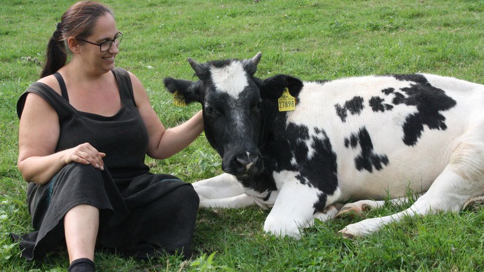 Eine Frau streichelt eine Kuh