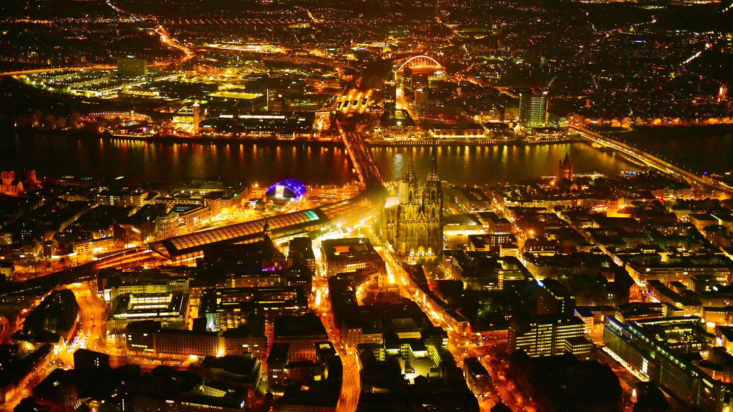 Köln: Dom und Hauptbahnhof  Wie flüssiges Gold, das durch die Straßen rinnt, leuchtet das abendliche Köln. Deutlich aus dem Häusermeer ragen Hauptbahnhof und der Dom hervor. Auf der anderen Rheinseite funkelt der Stadtteil Deutz.