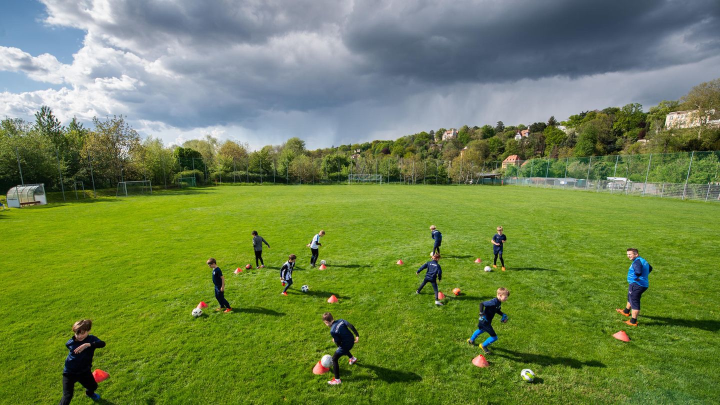 DOSB verlangt schnelle Öffnung von Sportstätten: Jugend-Fußballmannschaft trainiert auf einem Rasenplatz