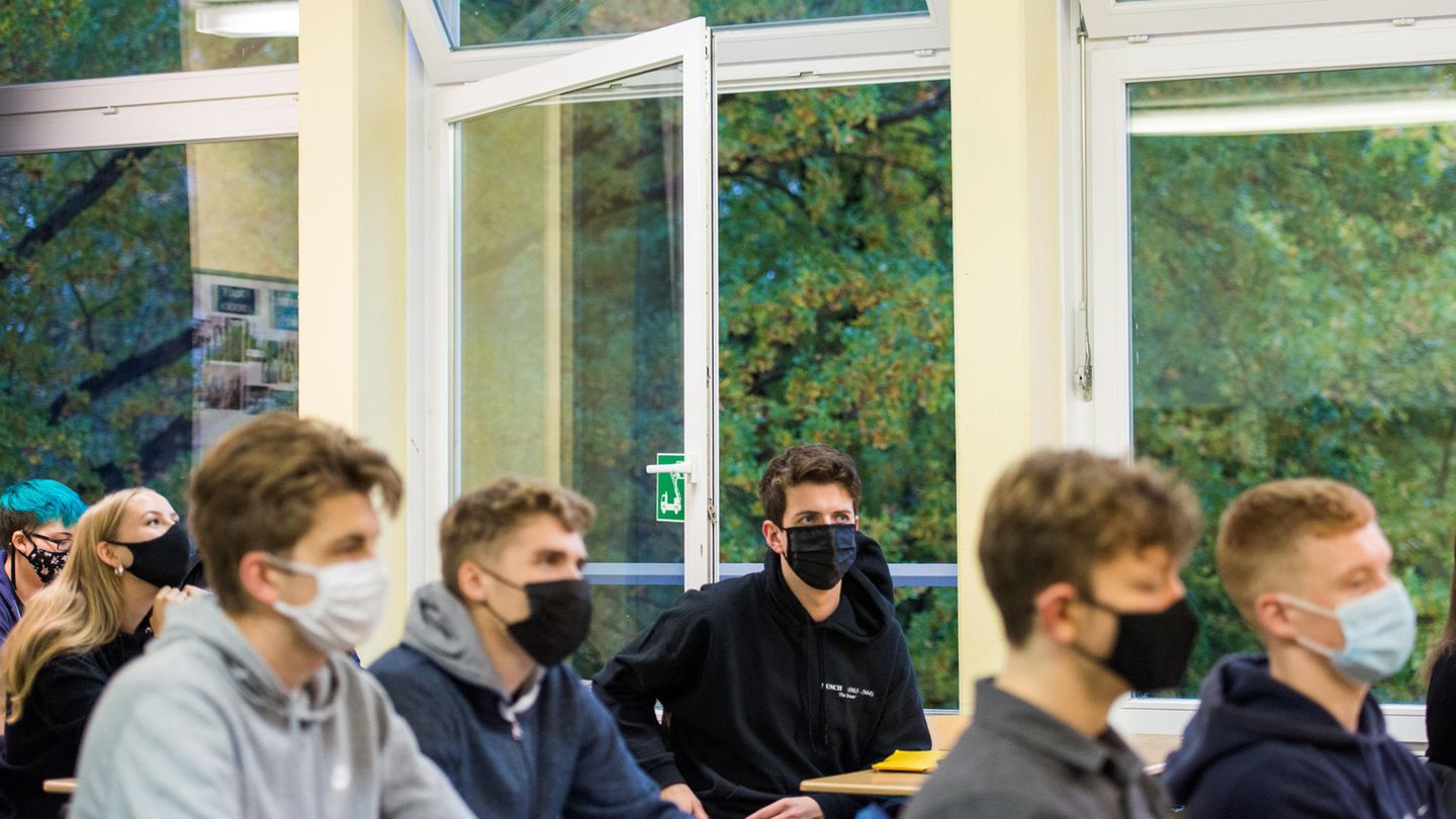 Hamburger Oberstufenschüler sitzen bei geöffneten Fenstern mit Maske im Unterricht