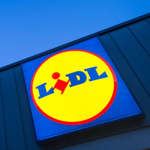 Ein Lidl-Logo auf einer blauen Wand vor dem blauen Himmel.