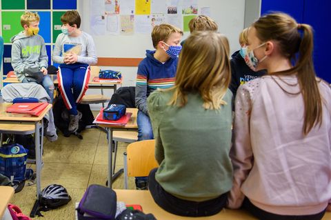 Schülerinnen und Schüler mit Mund-Nasen-Schutz gegen das Coronavirus im Schulunterricht