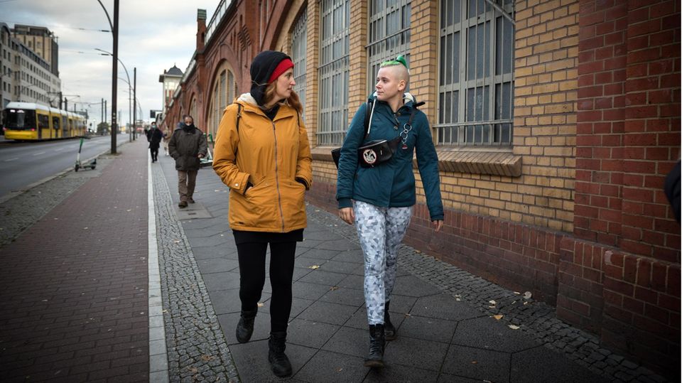 Streetworkerin Vici läuft mit Toni durch die Straße Streetworkerin Vici läuft mit Toni durch die Straße