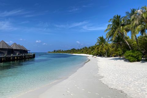 Fußabdrücke sind am leeren Strand der Insel Kuredu, Malediven zu sehen.