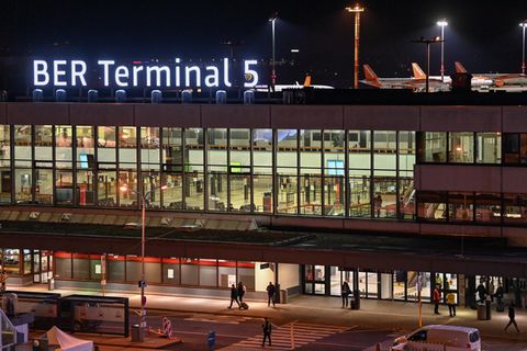 Der neue Schriftzug "BER Terminal 5" leuchtet am Abend auf dem Dach vom ehemaligen Flughafens Berlin Schönefeld