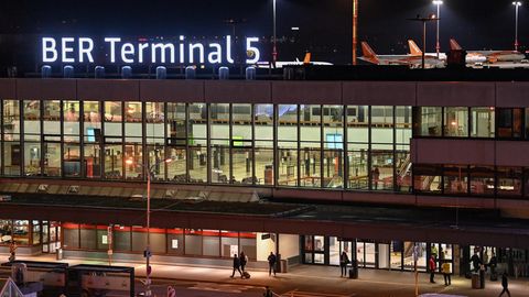 Der neue Schriftzug "BER Terminal 5" leuchtet am Abend auf dem Dach vom ehemaligen Flughafens Berlin Schönefeld