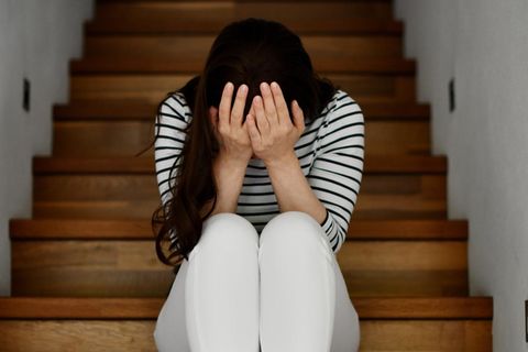 Eine Frau sitzt auf einer Treppe und ist verzweifelt